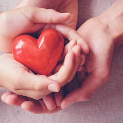 adult and child hands holiding red heart, health care, love, donate, insurance and family concept